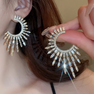 Golden C-shaped earrings with sparkling cubic zirconia crystals and sunburst pattern