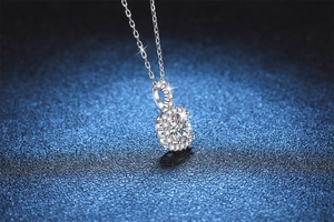 Macro shot of 1 carat moissanite halo pendant with brilliant round cut and fine silver chain