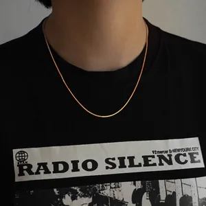 Collier chaîne serpent dorée minimaliste pour femme porté par un mannequin
