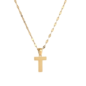 Macro view of gold-plated letter T pendant necklace with textured dot pattern detail