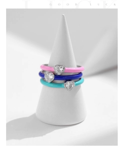 Detail view of stacked S925 silver rings with colorful enamel and heart-shaped zircon stones