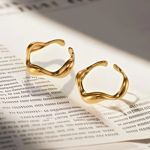 Detailed view of two gold wavy irregular rings on a vintage newspaper background