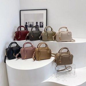 Handwoven Boston pillow bags in multiple colors with top handles and shoulder straps