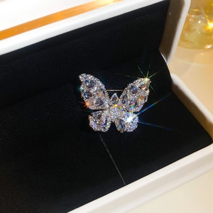 Close-up of sparkling silver butterfly brooch with pear-cut zircon on black velvet
