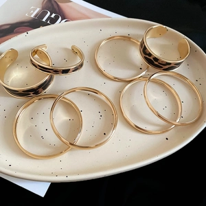 Detail view of gold alloy bangle set featuring leopard print patterns on elegant ceramic tray