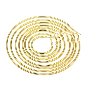 Set of six pairs of polished gold hoop earrings in graduated sizes on white background
