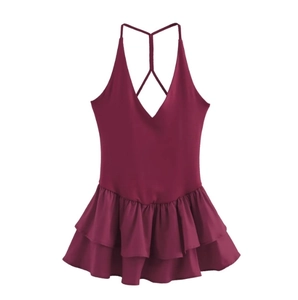 Detail of burgundy backless dress with adjustable crisscross straps and ruffled hem
