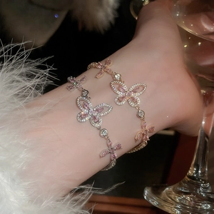 Detail of cherry blossom pink zircon butterfly bracelet in gold and silver finish