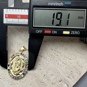 Detailed view of Virgin Mary pendant with colorful gems being measured by digital calipers