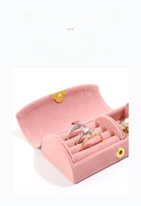 Pink velvet jewelry box with ring slots and snap closure for travel storage