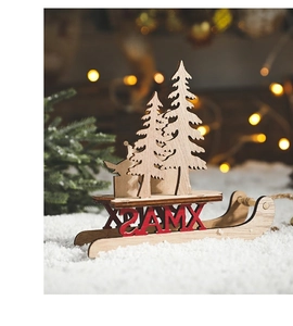Close-up of wooden Christmas sleigh ornament with XMAS lettering on artificial snow