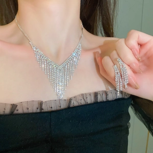 Detailed view of silver rhinestone tassel necklace and matching earrings on model