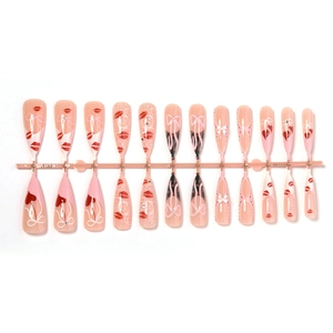 French lace press-on nails with red lip prints and pink bows on a flat layout