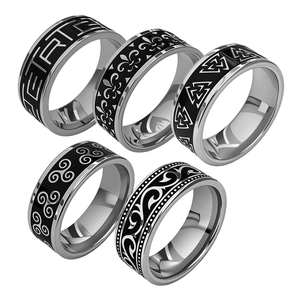 Detail view of five vintage titanium steel rings with black enamel geometric patterns
