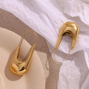 Gros plan de boucles d'oreilles épingle à nourrice plaquées or 18 carats sur céramique