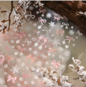 Detail of pink and white bow snowflake nail stickers with winter decorative accents