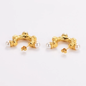 Vintage gold wavy earrings with pearls and diamond accents on white background
