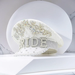Detail of white bridal captain hat featuring BRIDE pearl lettering and rhinestone crown