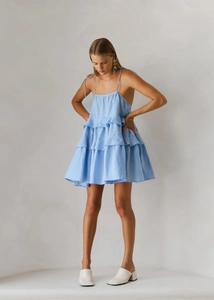Detail of light blue tiered ruffle summer dress with thin straps and airy cotton fabric