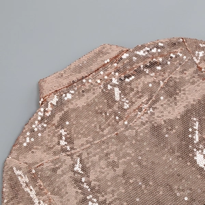 Detail of rose gold sequins on garment collar and shoulder with metallic shimmer