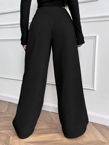 Rear view of women's loose wide-leg pants in black with elastic drawstring waist detail