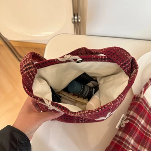 Detail of red plaid wool bag showing its soft texture and spacious interior storage