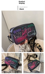 Close-up of black graffiti crossbody bag with colorful text and woven shoulder strap