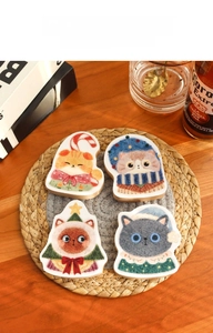 Close-up of four cat-shaped wooden bottle openers with festive Christmas-themed painted designs