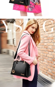 Close-up of black PU leather handbag with gold circular charm and Danbaoly logo