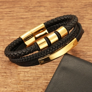 Close-up of multilayer black braided leather bracelet with gold magnetic metal clasp