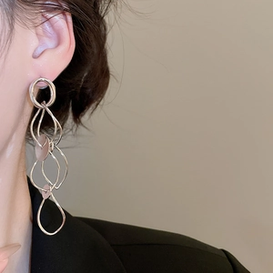 Close-up of elegant silver tassel drop earrings featuring layered geometric circular design