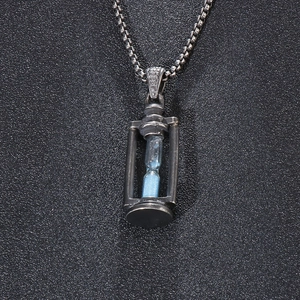 Macro shot of retro hourglass pendant with blue sand and vintage stainless steel finish