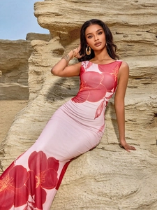 Elegant backless halter floral maxi dress in pink and red print against rock background