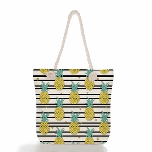 Detail of nautical rope handles on a canvas beach bag with pineapple print