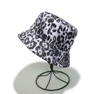 Dettaglio di un cappello da sole con stampa leopardata bianca e nera su supporto espositivo