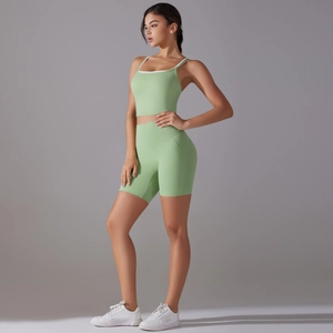 Close-up of mint green yoga set featuring white piping and high-waist cycling shorts