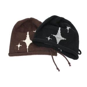 Close-up of vintage knit beanies with star patterns and drawstrings on white background