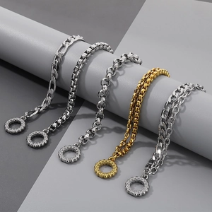 Dettaglio di varie catene in argento e oro con chiusure OT su supporti grigi