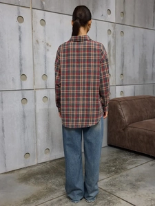 Women's vintage plaid long sleeve shirt jacket styled with denim in industrial setting