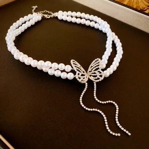 Elegant double-layer pearl necklace with a sparkling diamond butterfly tassel pendant