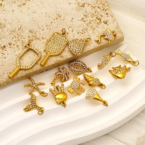 Polished gold ocean series pendants with cubic zirconia on a stone display stand
