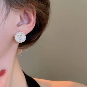 Gros plan de boucles d'oreilles perles élégantes avec nœud doré sur un modèle