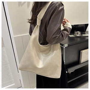 Detail of cream hobo shoulder bag featuring soft faux leather and a knotted strap design