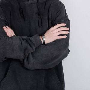 Close-up of braided black leather bracelet with silver buckle on male model wrist