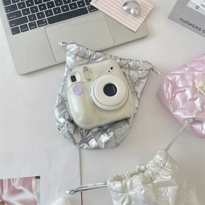 Close-up of quilted drawstring bags in metallic silver and pink for mini cameras