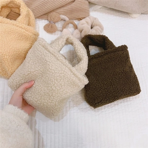 Détail de mini sacs à main en laine d'agneau pelucheuse en crème, beige et marron