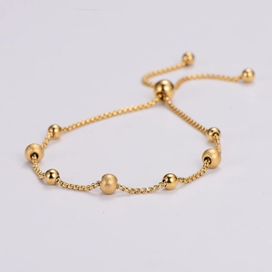 Adjustable golden box chain bracelet with polished and frosted beads on white background