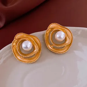 Vintage gold hollow flower pearl earrings with spiral texture and matte finish