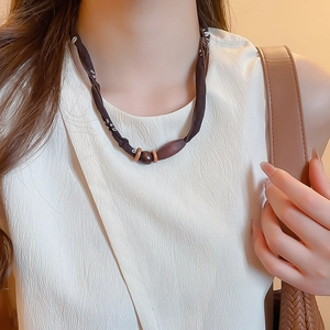 Close-up of vintage brown paisley silk scarf necklace with polished dark wood beads