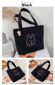 Detail of black corduroy tote bag with rabbit embroidery and cow plush keychain